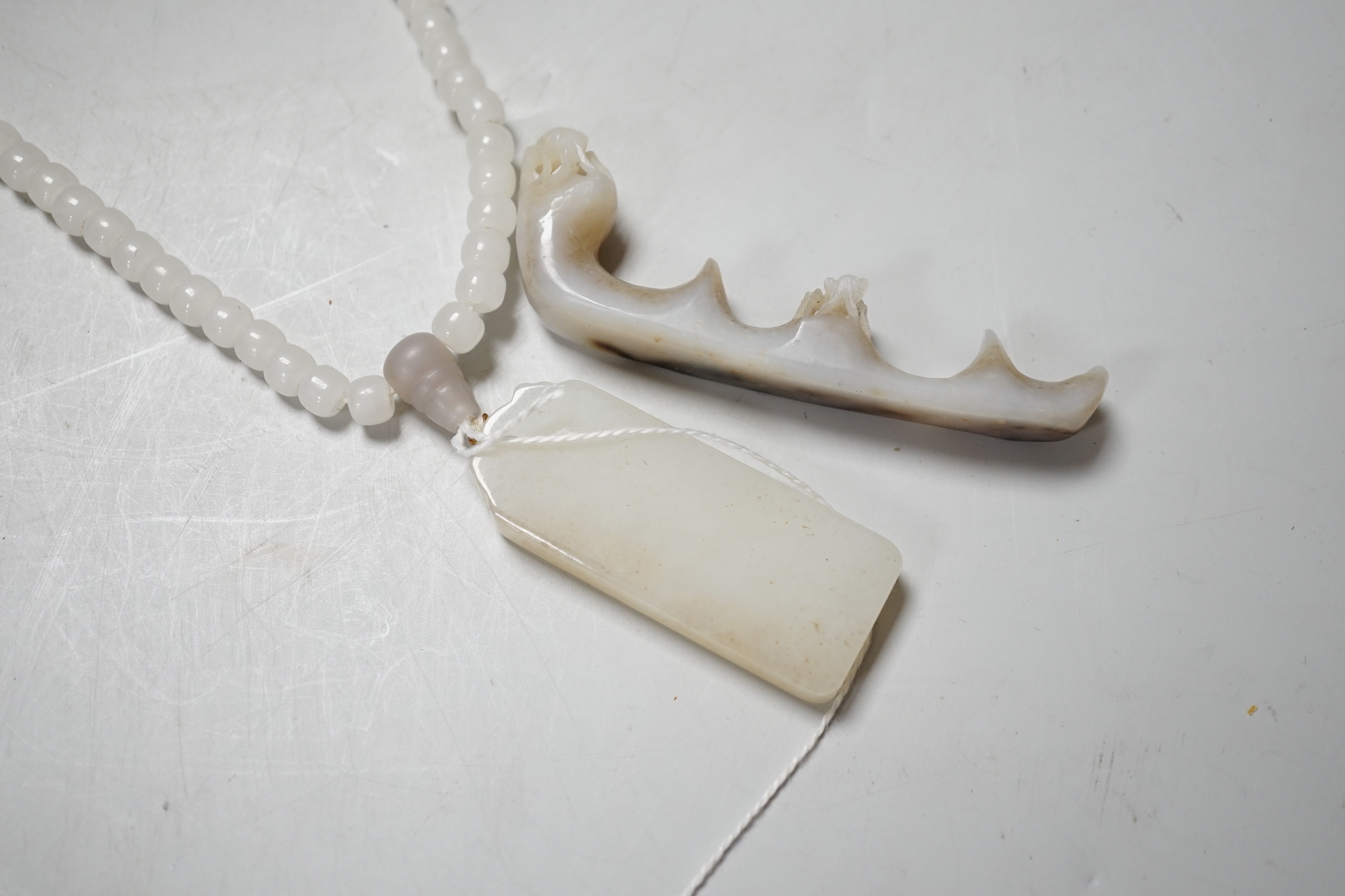 A Chinese white jade pendant and a jade brush rest